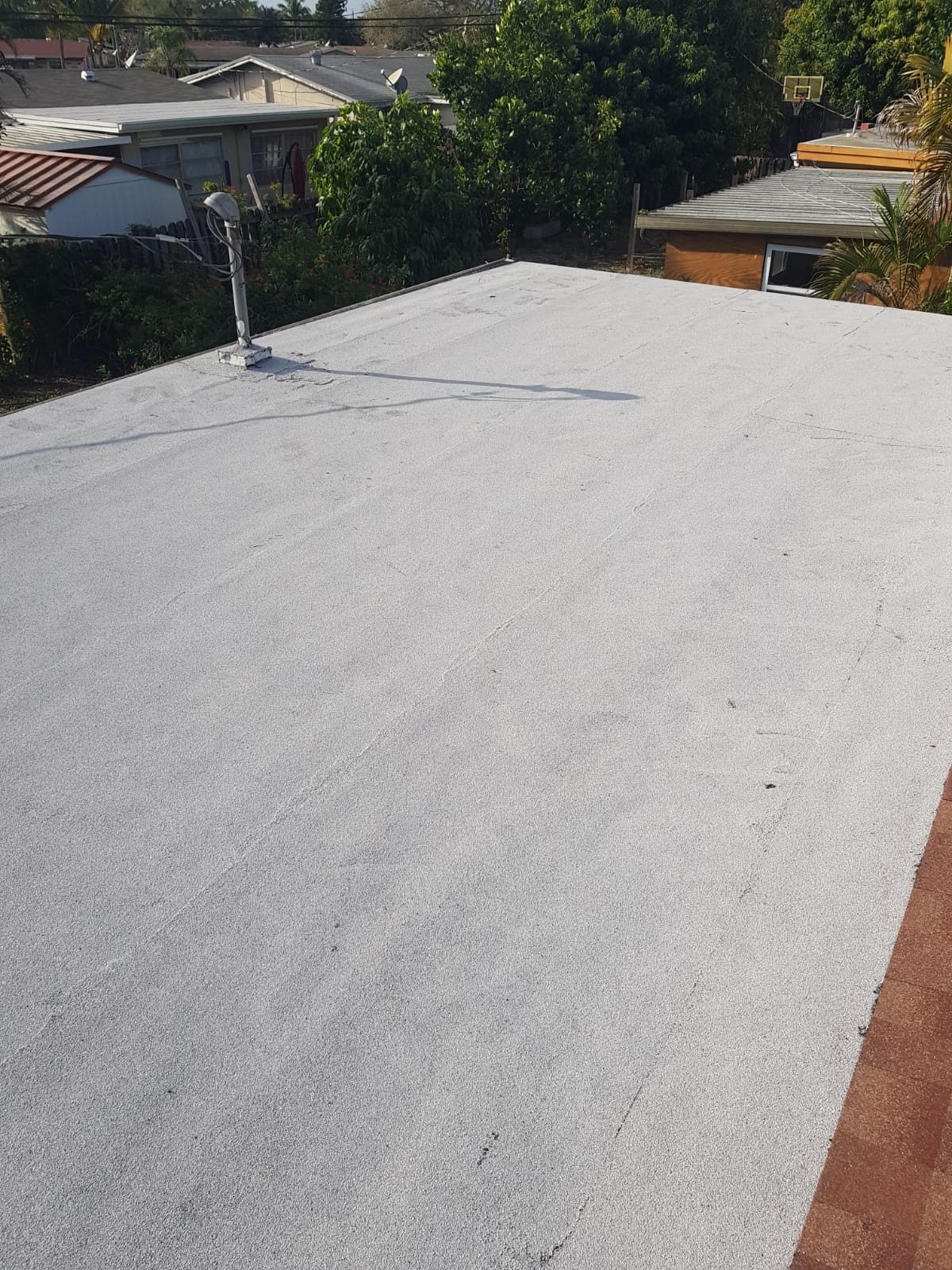 An elevated view of a clean, white flat roof surface.