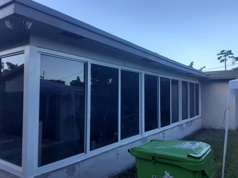 Newly installed tinted windows with white frames on a home exterior.