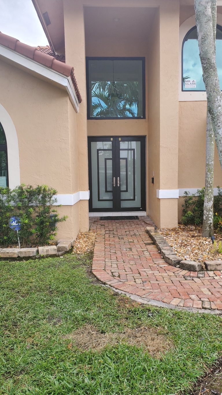 Modern double front doors with frosted glass and black frames.