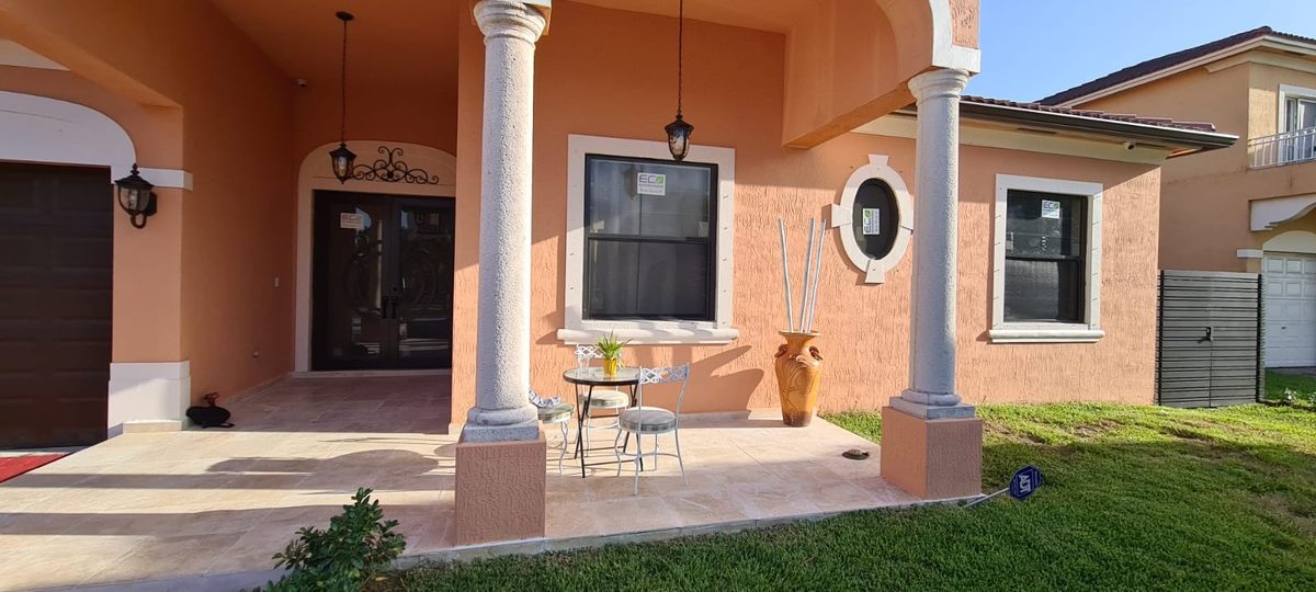 A residential porch with newly installed impact windows and glass doors.